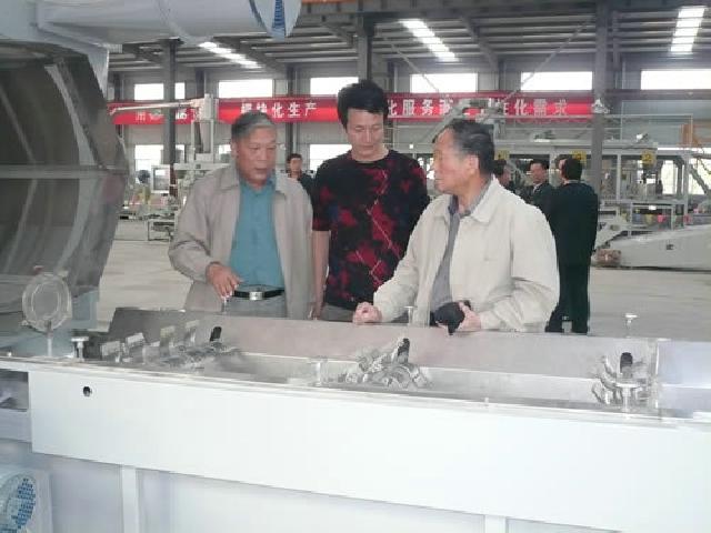  [CN]農(nóng)科院茶葉研究所研究員權(quán)啟愛(左)俞永明(右)宜昌蕭氏集團(tuán)董事長肖勇(中)在參觀清潔化生產(chǎn)線設(shè)備